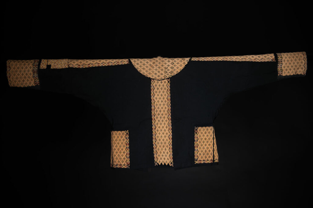 Male sleeve jacket from Rukai tribe , Black cotton and embroidered cloth pieces . This long sleeved short jacket is worn by noble men.