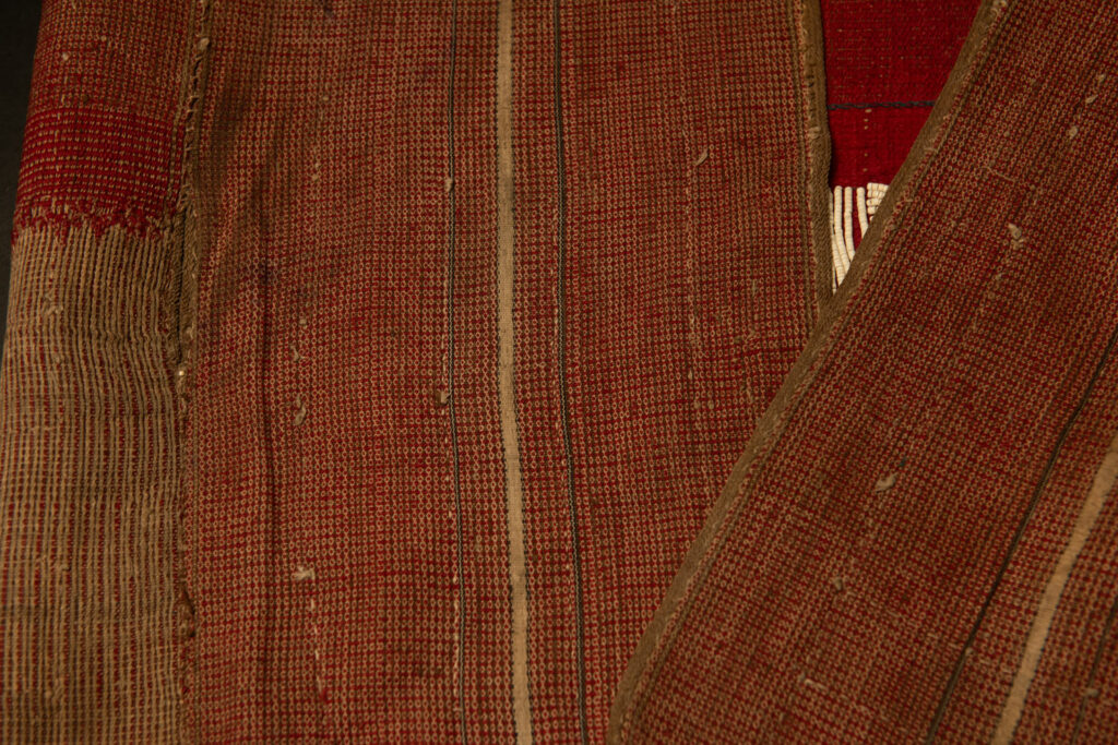 This beaded skirt from Attayal tribe is a piece of 89 cm long and 42 wide linen woven and embroidered with white shell beads. The white beads are made from giant clams. The Patterns are horizontal and vertical stripes . The upper part ( 14 cm ) is not beaded,