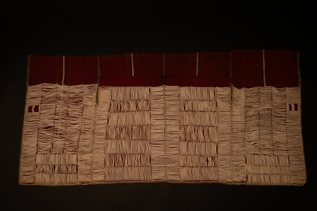 This beaded skirt from Attayal tribe is a piece of 89 cm long and 42 wide linen woven and embroidered with white shell beads. The white beads are made from giant clams. The Patterns are horizontal and vertical stripes . The upper part ( 14 cm ) is not beaded,
