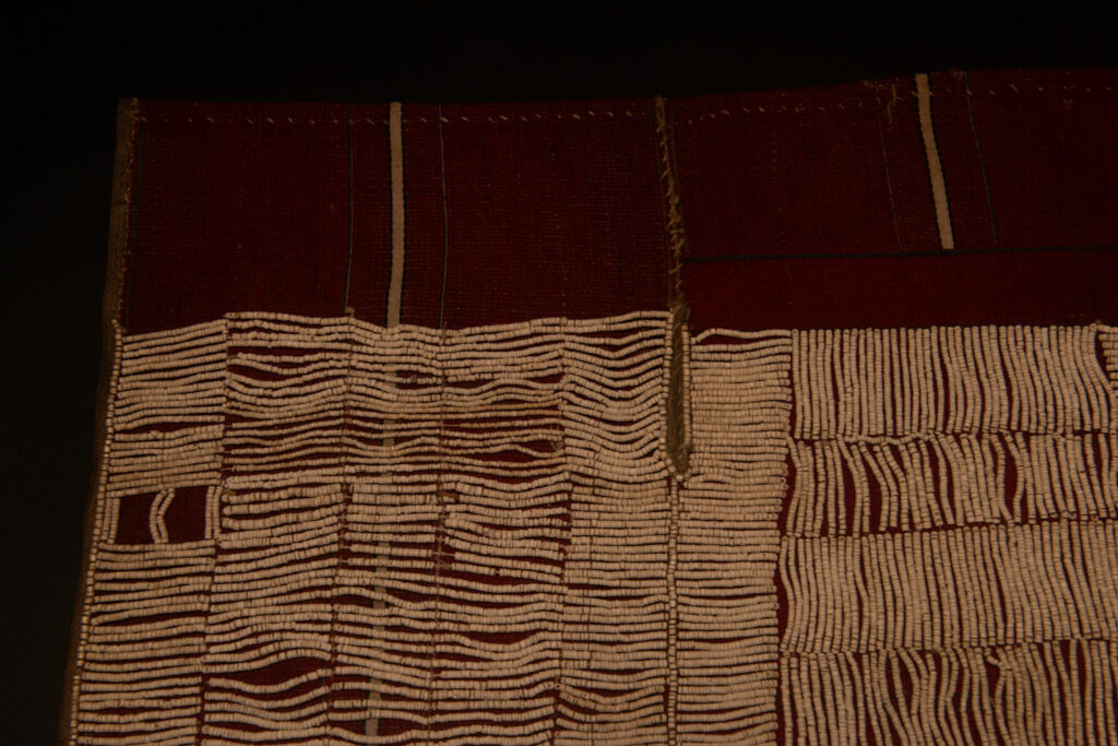 This beaded skirt from Attayal tribe is a piece of 89 cm long and 42 wide linen woven and embroidered with white shell beads. The white beads are made from giant clams. The Patterns are horizontal and vertical stripes . The upper part ( 14 cm ) is not beaded,