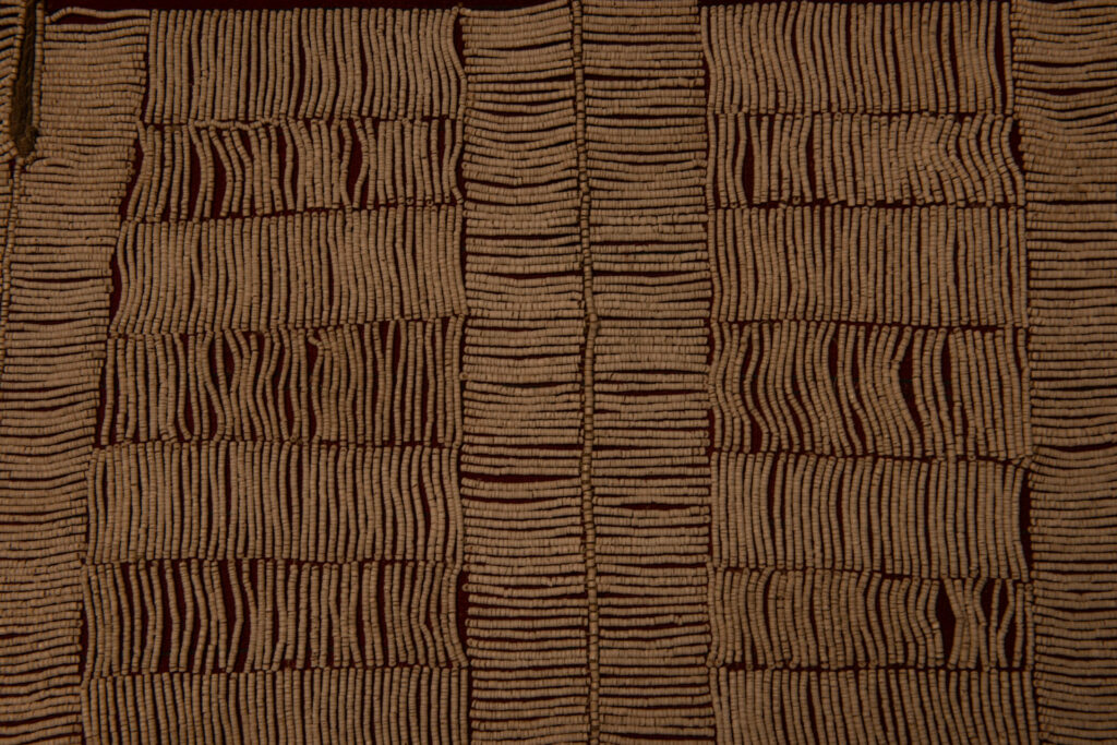 This beaded skirt from Attayal tribe is a piece of 89 cm long and 42 wide linen woven and embroidered with white shell beads. The white beads are made from giant clams. The Patterns are horizontal and vertical stripes . The upper part ( 14 cm ) is not beaded,