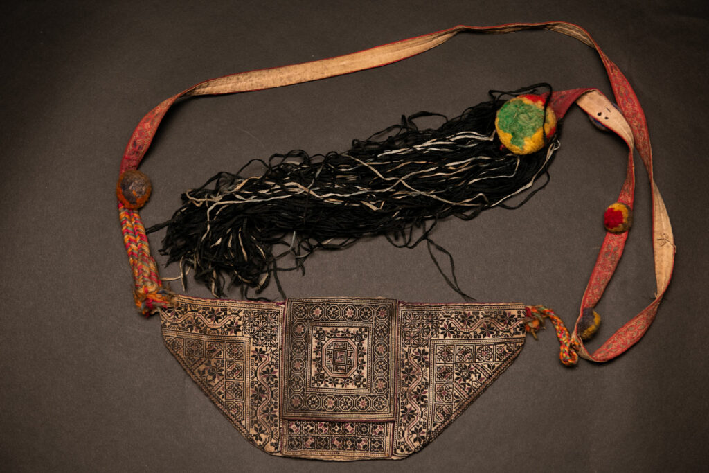 Ceremonial betel nut bag from the ami tribe, fully embroidered with distinctive motifs and inverted trapezoid shape.