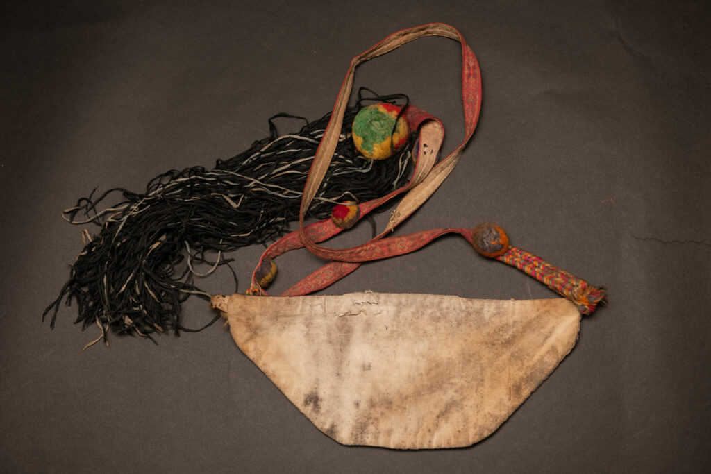 Ceremonial betel nut bag from the ami tribe, fully embroidered with distinctive motifs and inverted trapezoid shape.