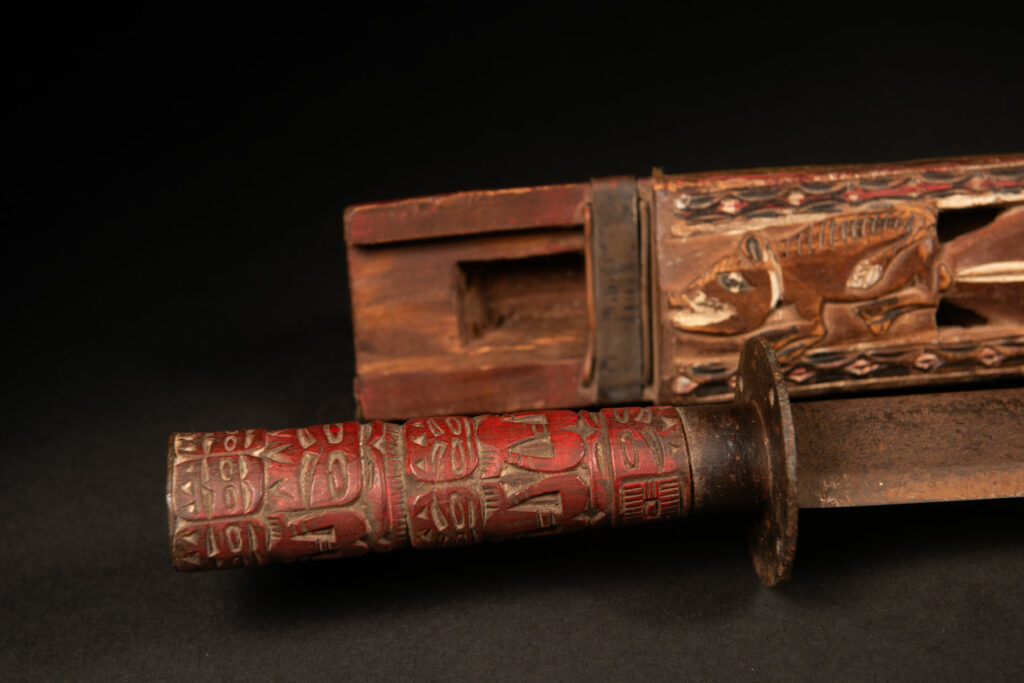 This ceremonial Paiwan sword is carved with a wild boar and a snake running along the entire length of the wooden scabbard.