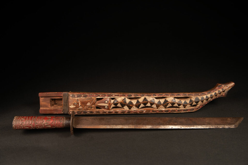 This ceremonial Paiwan sword is carved with a wild boar and a snake running along the entire length of the wooden scabbard.