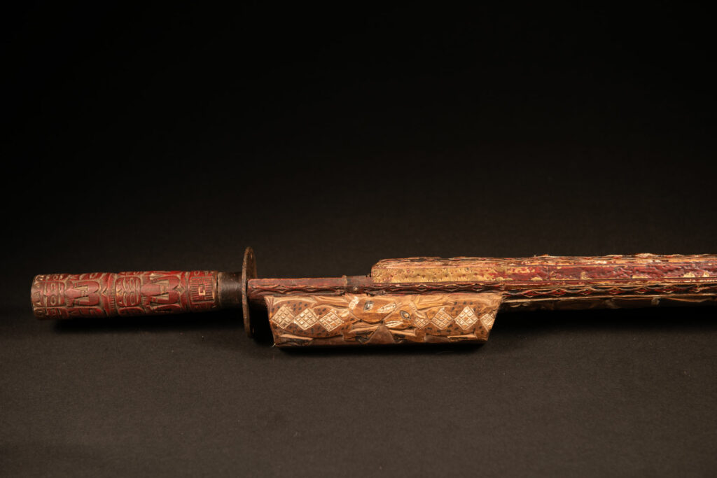 This ceremonial Paiwan sword is carved with a wild boar and a snake running along the entire length of the wooden scabbard.