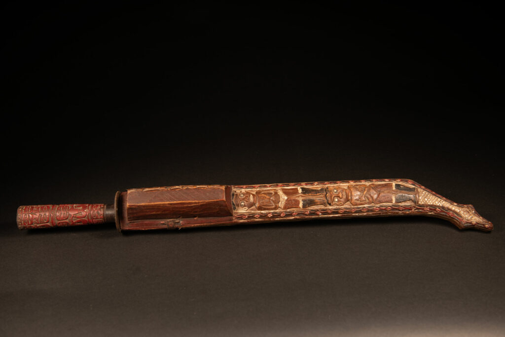 This ceremonial Paiwan sword is carved with a wild boar and a snake running along the entire length of the wooden scabbard.