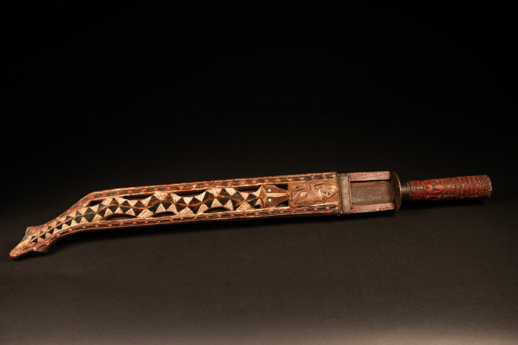 This ceremonial Paiwan sword is carved with a wild boar and a snake running along the entire length of the wooden scabbard.