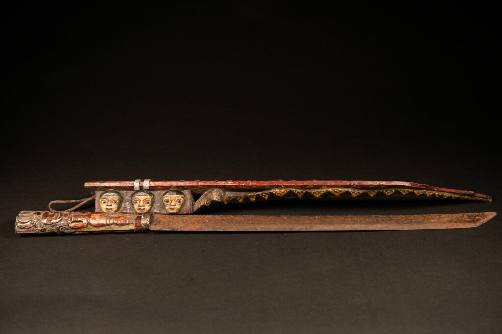 Very long Paiwan ceremonial sword featuring a scabbard carved with a snake and three human faces.