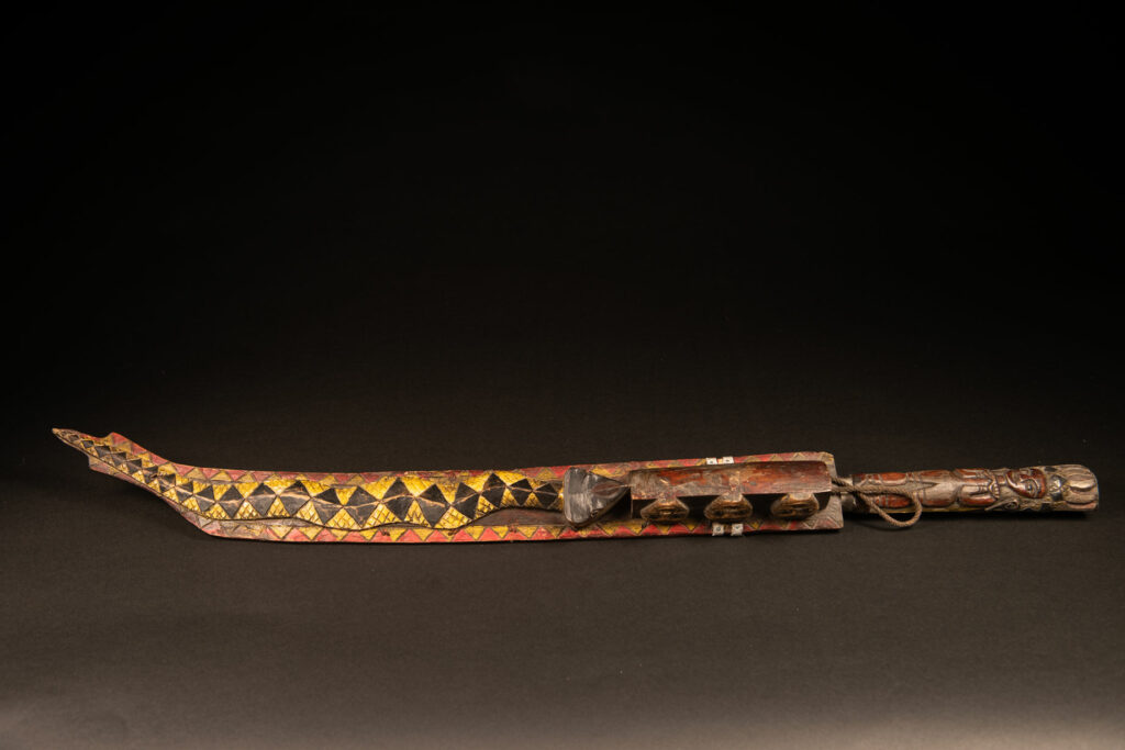 Very long Paiwan ceremonial sword featuring a scabbard carved with a snake and three human faces.