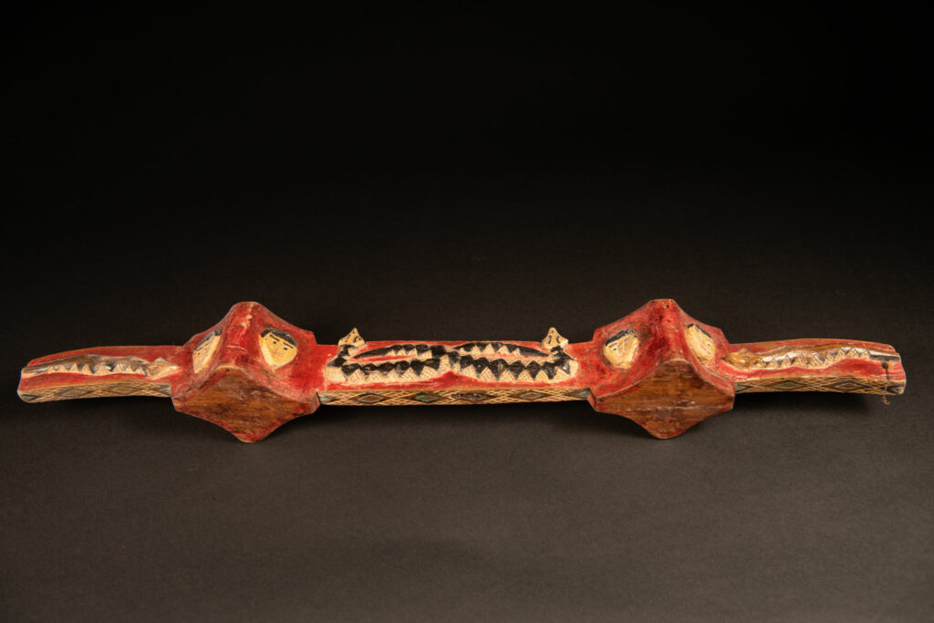 wine double cup engraved with snakes on the handles and in the center of the cup, and with human faces on the containers. The whole piece is enhanced with red, black, white, and green paint.