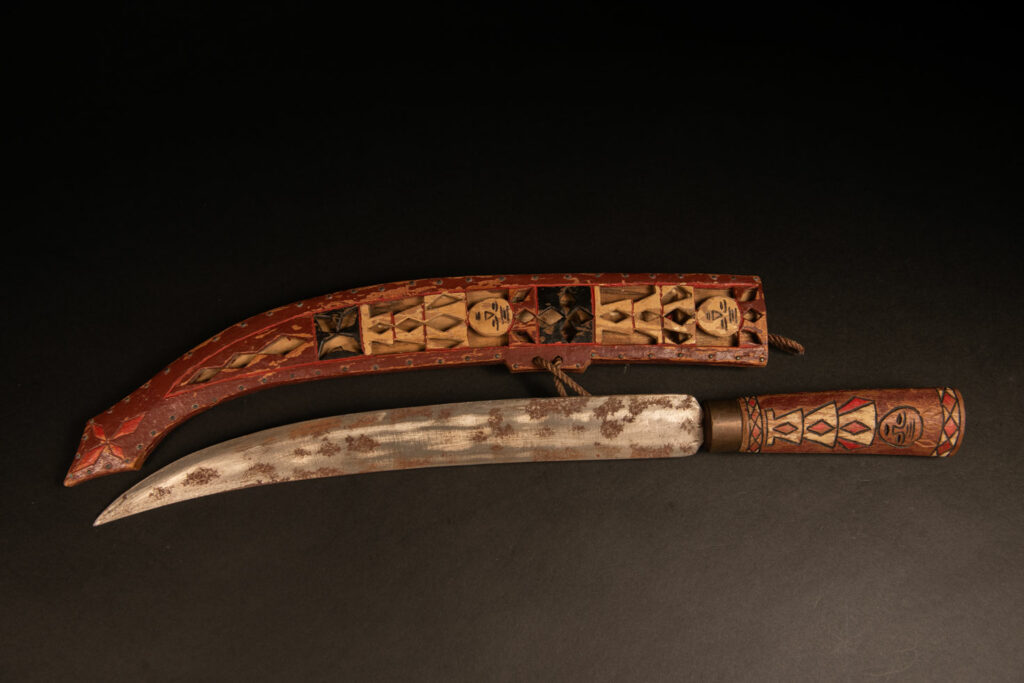 word from the Rukai tribe, painted in red, white, and black, engraved with serpent motifs and stylized human figures.