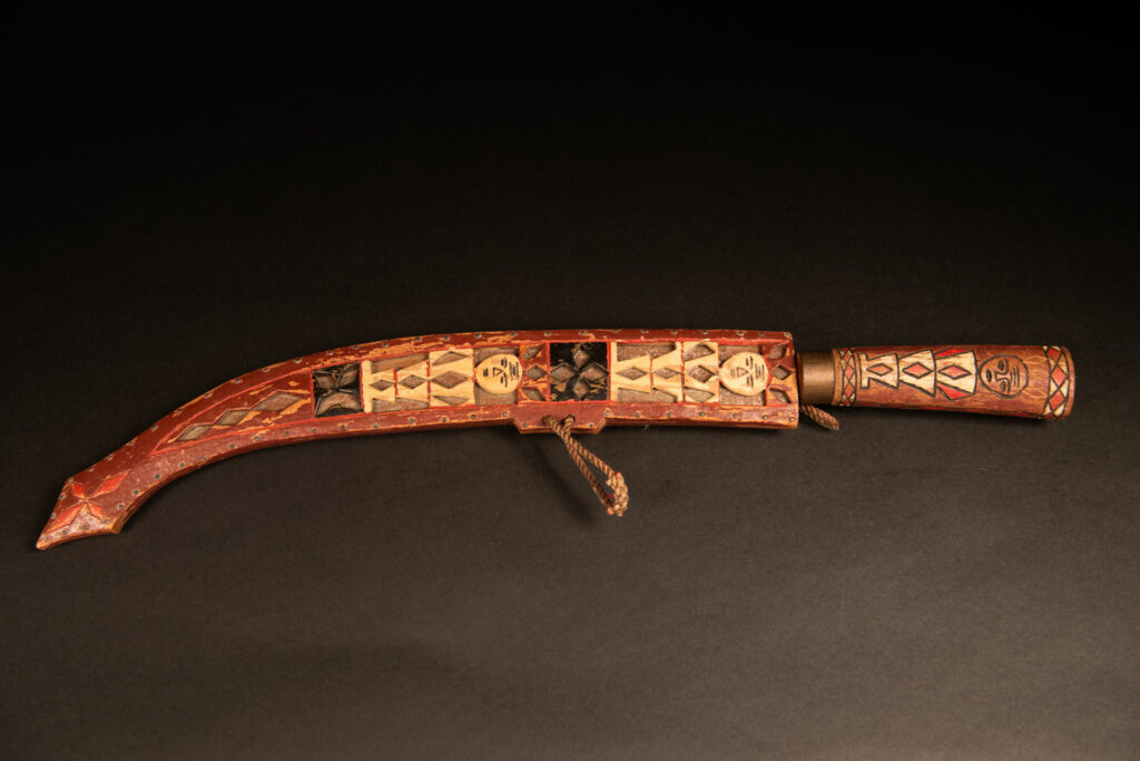 word from the Rukai tribe, painted in red, white, and black, engraved with serpent motifs and stylized human figures.
