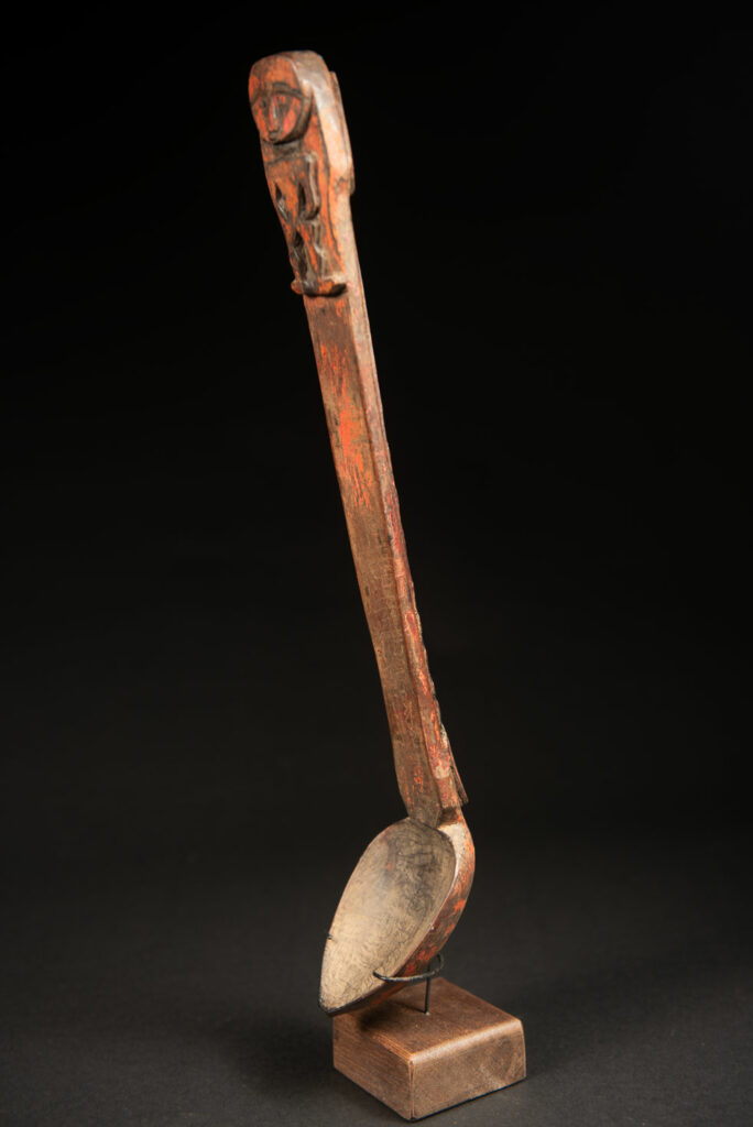 Beautiful 19th-century spoon, carved with a standing ancestor figure at the top and a magnificent double-headed serpent on the back. The spoon is stained red. Its size is 42 cm high.