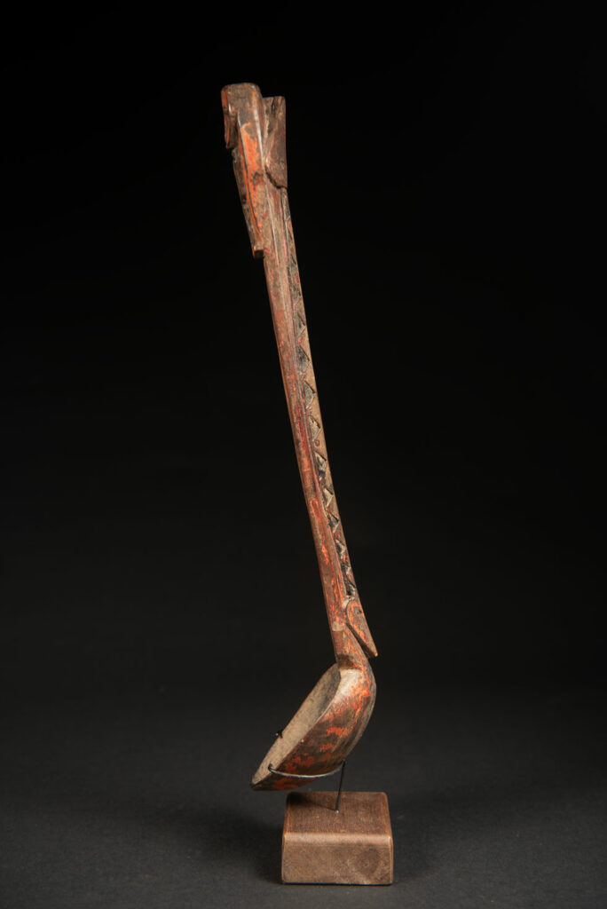 Beautiful 19th-century spoon, carved with a standing ancestor figure at the top and a magnificent double-headed serpent on the back. The spoon is stained red. Its size is 42 cm high.