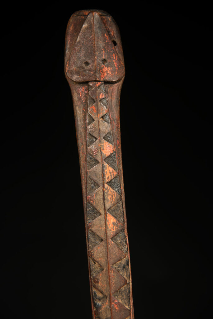 Beautiful 19th-century spoon, carved with a standing ancestor figure at the top and a magnificent double-headed serpent on the back. The spoon is stained red. Its size is 42 cm high.