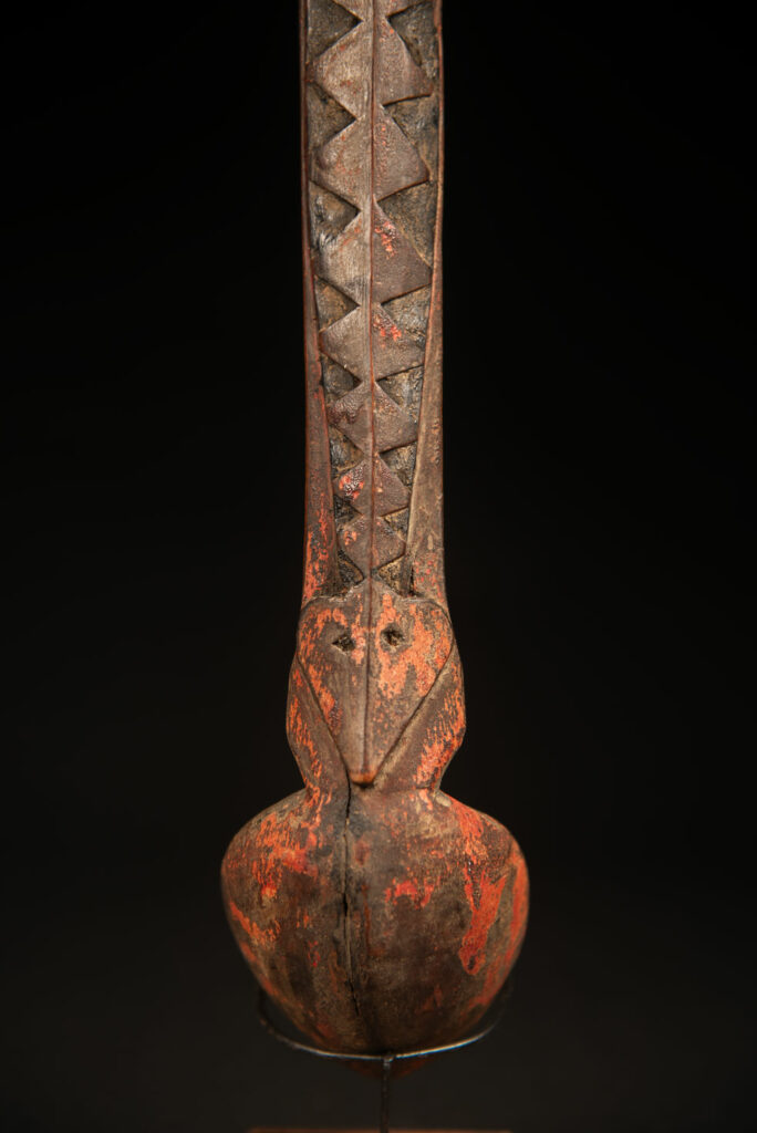 Beautiful 19th-century spoon, carved with a standing ancestor figure at the top and a magnificent double-headed serpent on the back. The spoon is stained red. Its size is 42 cm high.