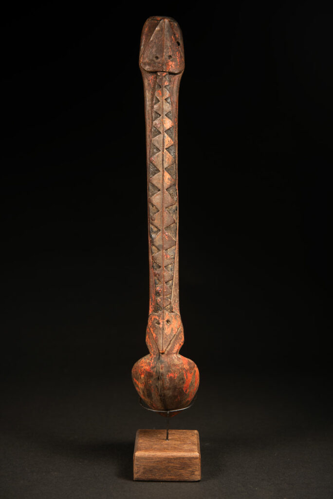 Beautiful 19th-century spoon, carved with a standing ancestor figure at the top and a magnificent double-headed serpent on the back. The spoon is stained red. Its size is 42 cm high.