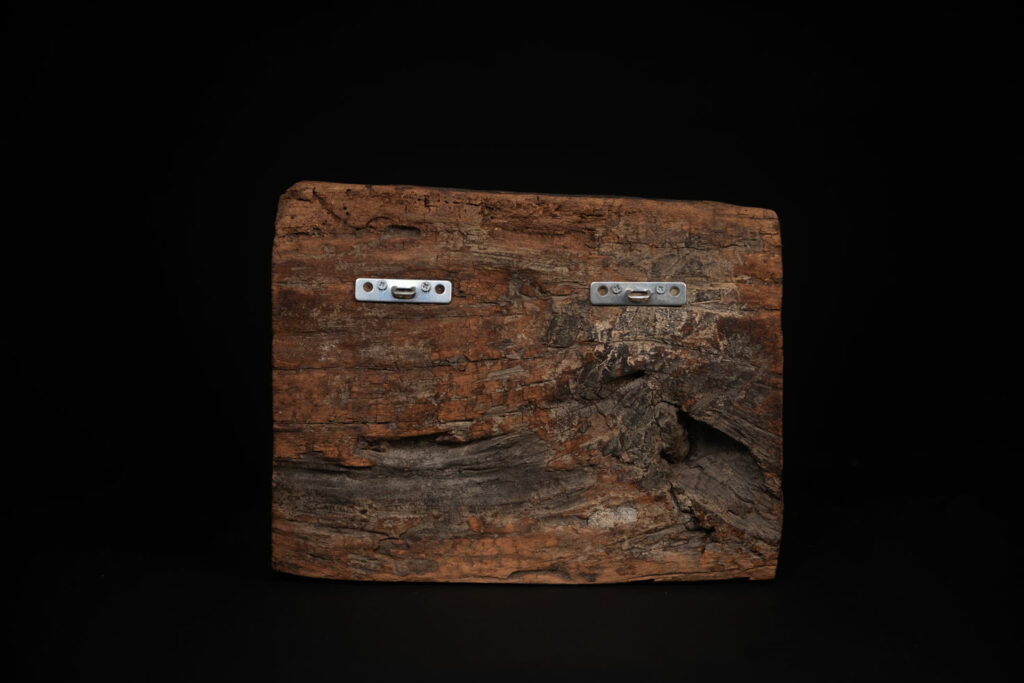 Paiwan tribe - Eave fragment carved with a central face surrounded by a sacred snake, and two faces flanked by deer.