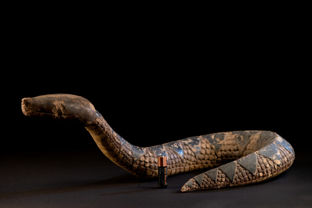This painted snake sculpture frequently found in Paiwan houses holds a spiritual significance comparable to that of the crucifix for Christians.