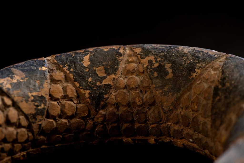 This painted snake sculpture frequently found in Paiwan houses holds a spiritual significance comparable to that of the crucifix for Christians.