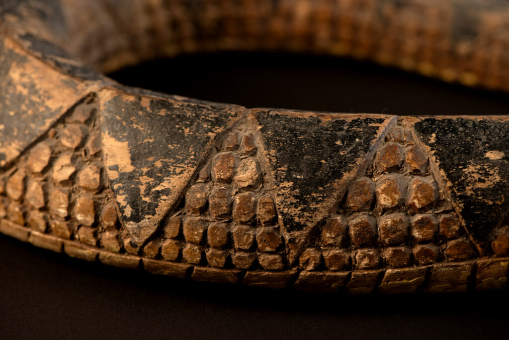 This painted snake sculpture frequently found in Paiwan houses holds a spiritual significance comparable to that of the crucifix for Christians.