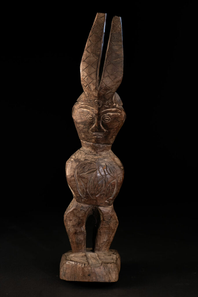 Paiwan tribe Statue depicting a male ancestor wearing a jacket and a ceremonial hat with huge eagle feather, sign of Valor and Vigor.