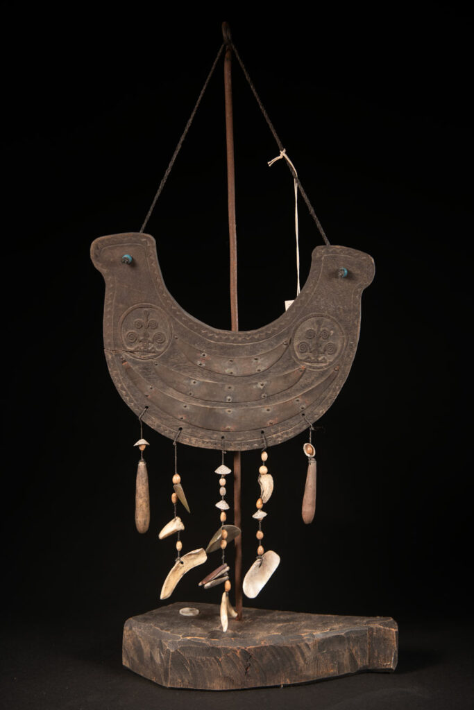 This half-moon-shaped chest ornament is made from wood chips of mangosteen, wuzhi (five-finger tree), or persimmon trees, and is traditionally worn by elderly men. Three arc-shaped copper pieces ( oxyded) of varying sizes are attached to the wooden base. The lower edge is adorned with various decorative elements considered beautiful.