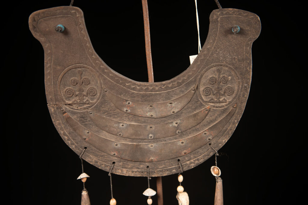 This half-moon-shaped chest ornament is made from wood chips of mangosteen, wuzhi (five-finger tree), or persimmon trees, and is traditionally worn by elderly men. Three arc-shaped copper pieces ( oxyded) of varying sizes are attached to the wooden base. The lower edge is adorned with various decorative elements considered beautiful.