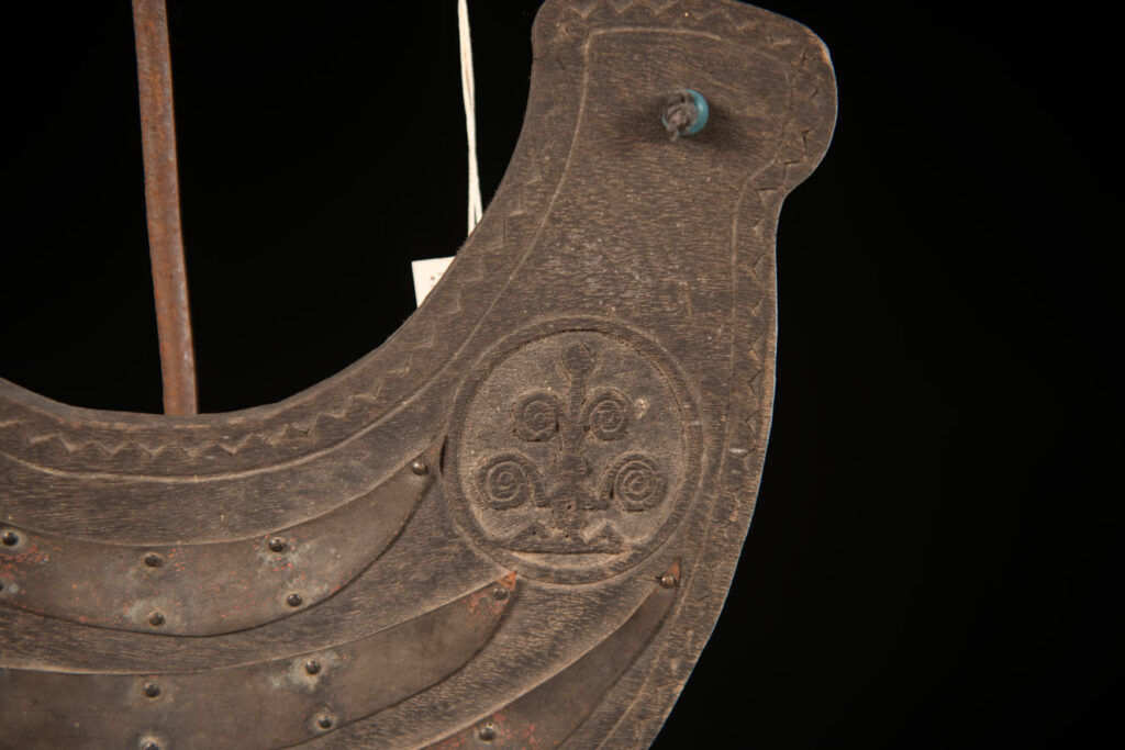 This half-moon-shaped chest ornament is made from wood chips of mangosteen, wuzhi (five-finger tree), or persimmon trees, and is traditionally worn by elderly men. Three arc-shaped copper pieces ( oxyded) of varying sizes are attached to the wooden base. The lower edge is adorned with various decorative elements considered beautiful.