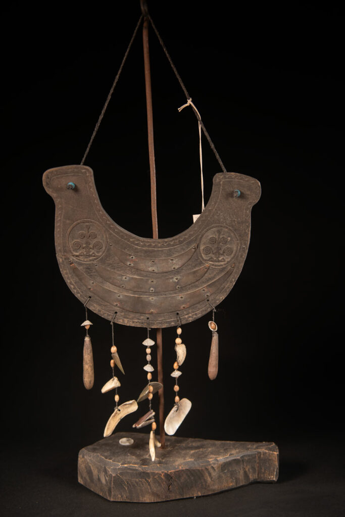 This half-moon-shaped chest ornament is made from wood chips of mangosteen, wuzhi (five-finger tree), or persimmon trees, and is traditionally worn by elderly men. Three arc-shaped copper pieces ( oxyded) of varying sizes are attached to the wooden base. The lower edge is adorned with various decorative elements considered beautiful.