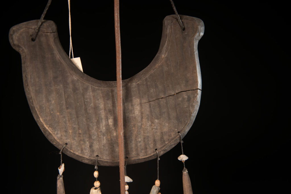 This half-moon-shaped chest ornament is made from wood chips of mangosteen, wuzhi (five-finger tree), or persimmon trees, and is traditionally worn by elderly men. Three arc-shaped copper pieces ( oxyded) of varying sizes are attached to the wooden base. The lower edge is adorned with various decorative elements considered beautiful.