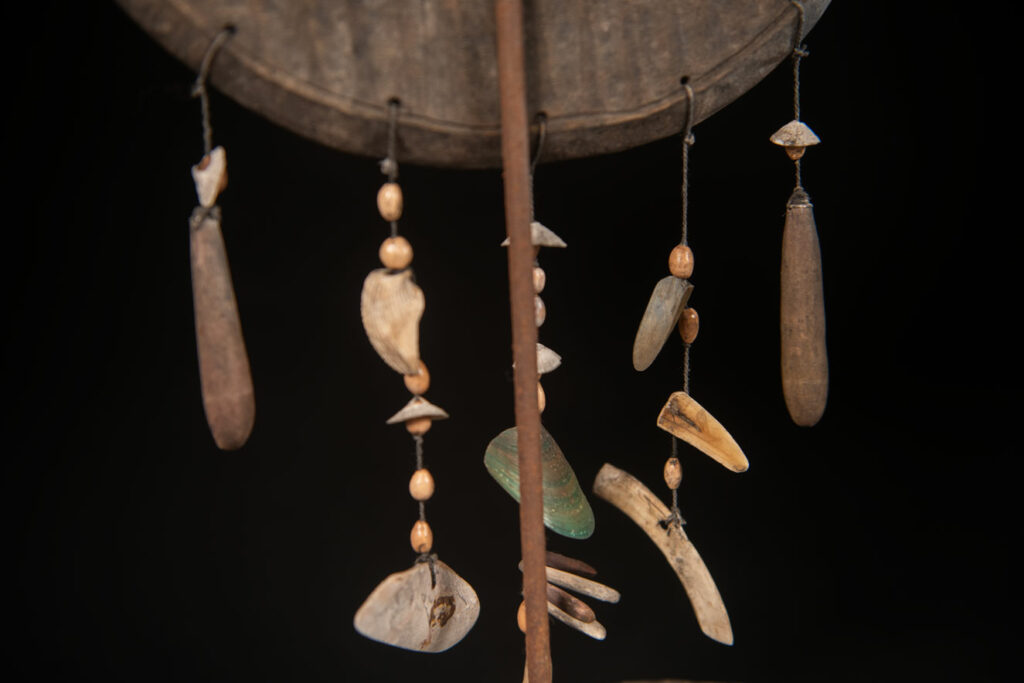 This half-moon-shaped chest ornament is made from wood chips of mangosteen, wuzhi (five-finger tree), or persimmon trees, and is traditionally worn by elderly men. Three arc-shaped copper pieces ( oxyded) of varying sizes are attached to the wooden base. The lower edge is adorned with various decorative elements considered beautiful.