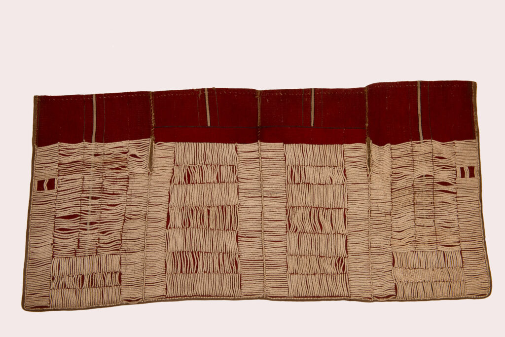 This beaded skirt from Attayal tribe is a piece of 89 cm long and 42 wide linen woven and embroidered with white shell beads. The white beads are made from giant clams. The Patterns are horizontal and vertical stripes . The upper part ( 14 cm ) is not beaded,