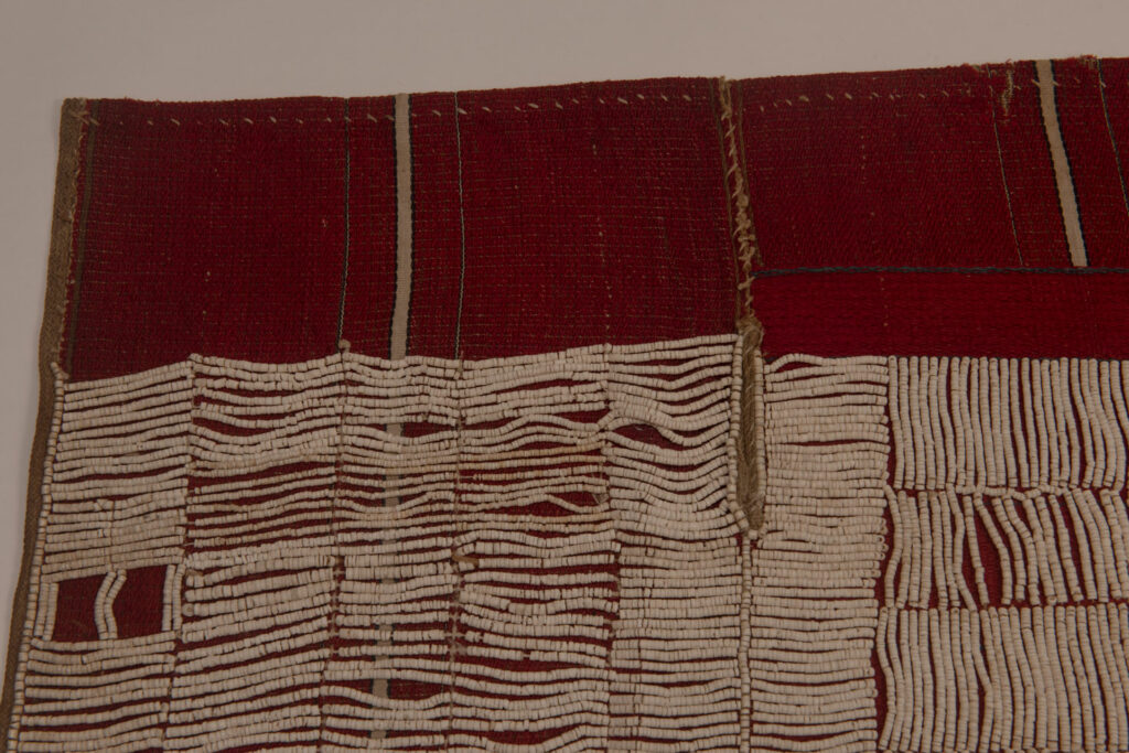 This beaded skirt from Attayal tribe is a piece of 89 cm long and 42 wide linen woven and embroidered with white shell beads. The white beads are made from giant clams. The Patterns are horizontal and vertical stripes . The upper part ( 14 cm ) is not beaded,