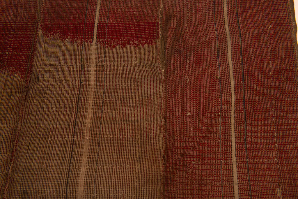 This beaded skirt from Attayal tribe is a piece of 89 cm long and 42 wide linen woven and embroidered with white shell beads. The white beads are made from giant clams. The Patterns are horizontal and vertical stripes . The upper part ( 14 cm ) is not beaded,