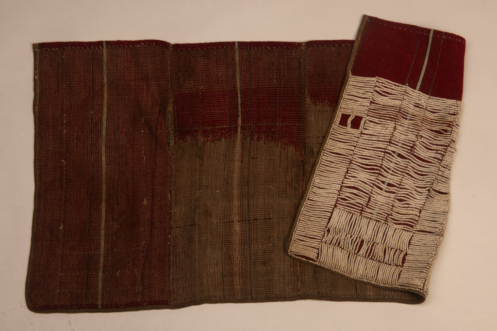 This beaded skirt from Attayal tribe is a piece of 89 cm long and 42 wide linen woven and embroidered with white shell beads. The white beads are made from giant clams. The Patterns are horizontal and vertical stripes . The upper part ( 14 cm ) is not beaded,