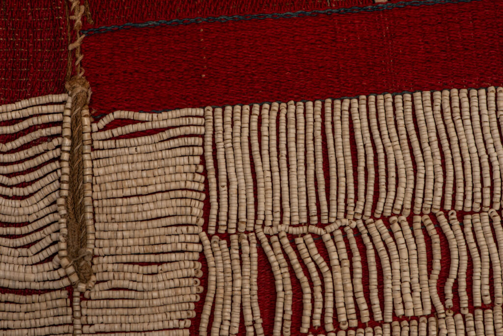 This beaded skirt from Attayal tribe is a piece of 89 cm long and 42 wide linen woven and embroidered with white shell beads. The white beads are made from giant clams. The Patterns are horizontal and vertical stripes . The upper part ( 14 cm ) is not beaded,