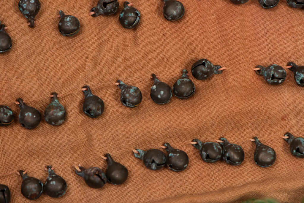Pair of women’s legging from the Ami tribe, made of pink cotton fabric with orange and black stripes, sewn with ten rows of small bells. The bottom of each piece is adorned with green woolen knots. Such ankle ornaments were worn by women during ceremonies and festivals. This pair is estimated to date from the 1950s.