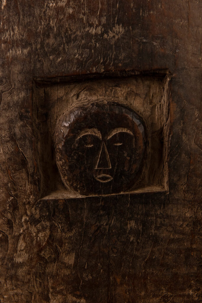 Rare and massive early 19th-century panel from the East Coast Paiwan tribe, carved in the Taimali style. It features a prominent central nose, a stylized face at the top, and another face carved at the bottom — a characteristic design of the Southeastern Paiwan tradition.