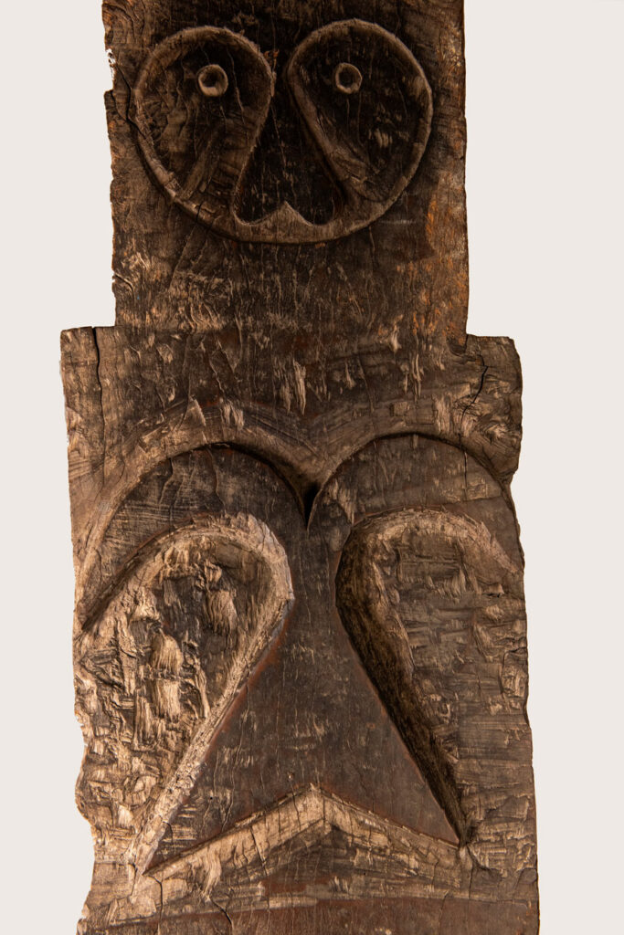Rare and massive early 19th-century panel from the East Coast Paiwan tribe, carved in the Taimali style. It features a prominent central nose, a stylized face at the top, and another face carved at the bottom — a characteristic design of the Southeastern Paiwan tradition.