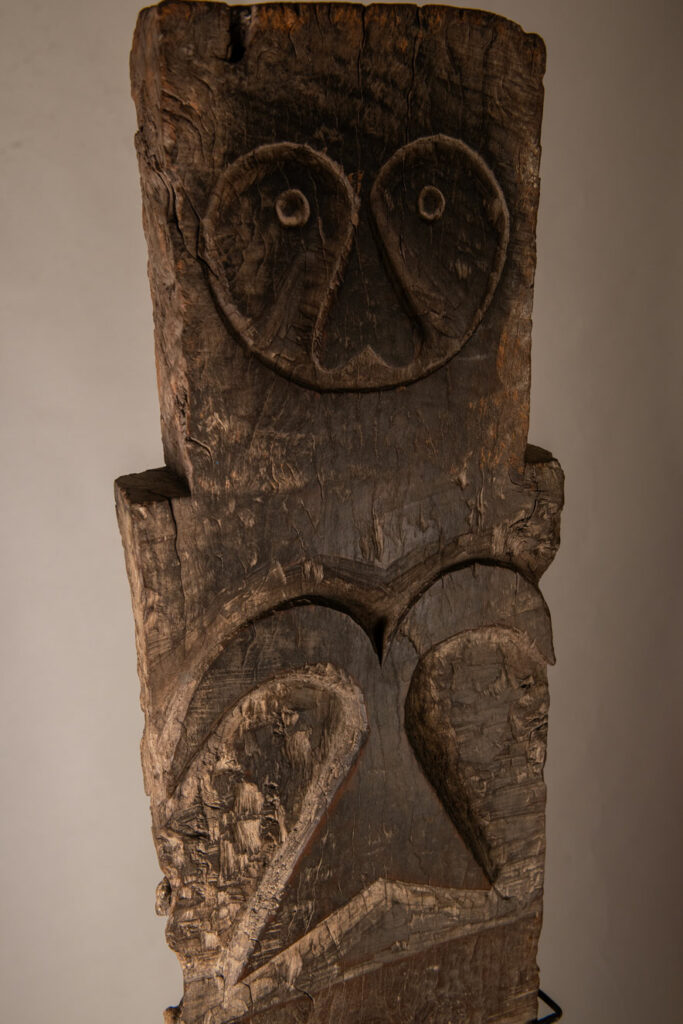 Rare and massive early 19th-century panel from the East Coast Paiwan tribe, carved in the Taimali style. It features a prominent central nose, a stylized face at the top, and another face carved at the bottom — a characteristic design of the Southeastern Paiwan tradition.