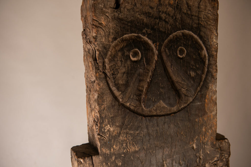 Rare and massive early 19th-century panel from the East Coast Paiwan tribe, carved in the Taimali style. It features a prominent central nose, a stylized face at the top, and another face carved at the bottom — a characteristic design of the Southeastern Paiwan tradition.