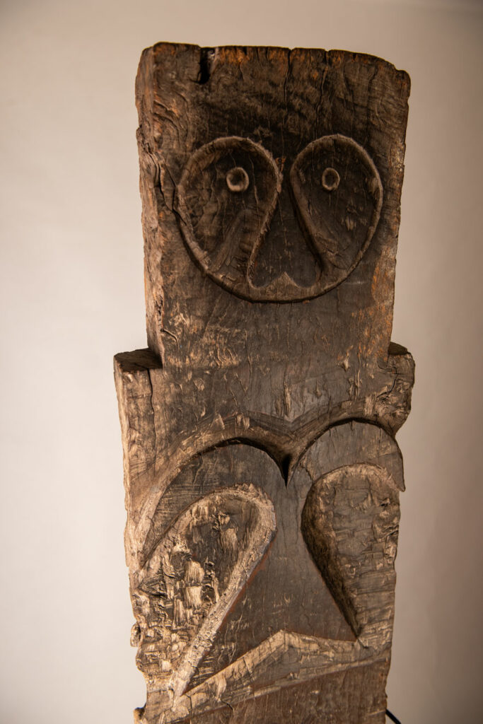 Rare and massive early 19th-century panel from the East Coast Paiwan tribe, carved in the Taimali style. It features a prominent central nose, a stylized face at the top, and another face carved at the bottom — a characteristic design of the Southeastern Paiwan tradition.