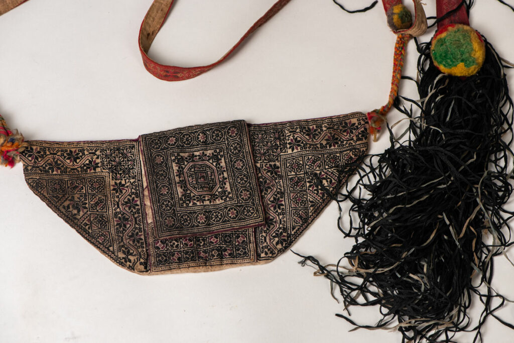 Ceremonial betel nut bag from the ami tribe, fully embroidered with distinctive motifs and inverted trapezoid shape.