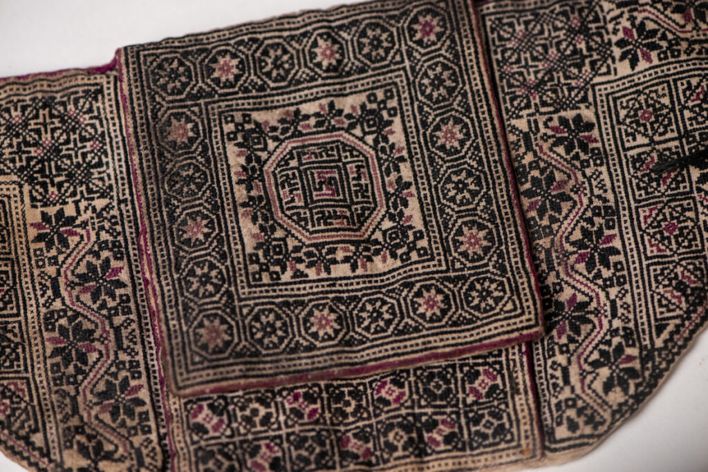 Ceremonial betel nut bag from the ami tribe, fully embroidered with distinctive motifs and inverted trapezoid shape.