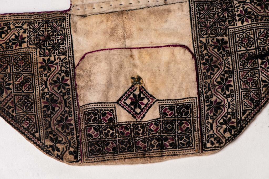 Ceremonial betel nut bag from the ami tribe, fully embroidered with distinctive motifs and inverted trapezoid shape.