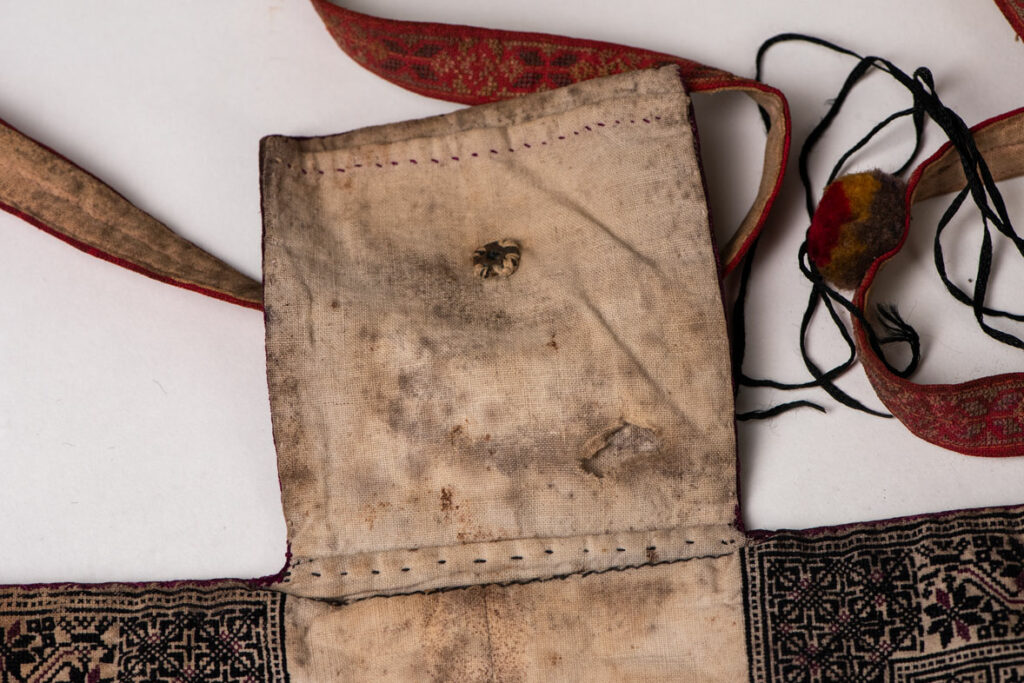 Ceremonial betel nut bag from the ami tribe, fully embroidered with distinctive motifs and inverted trapezoid shape.