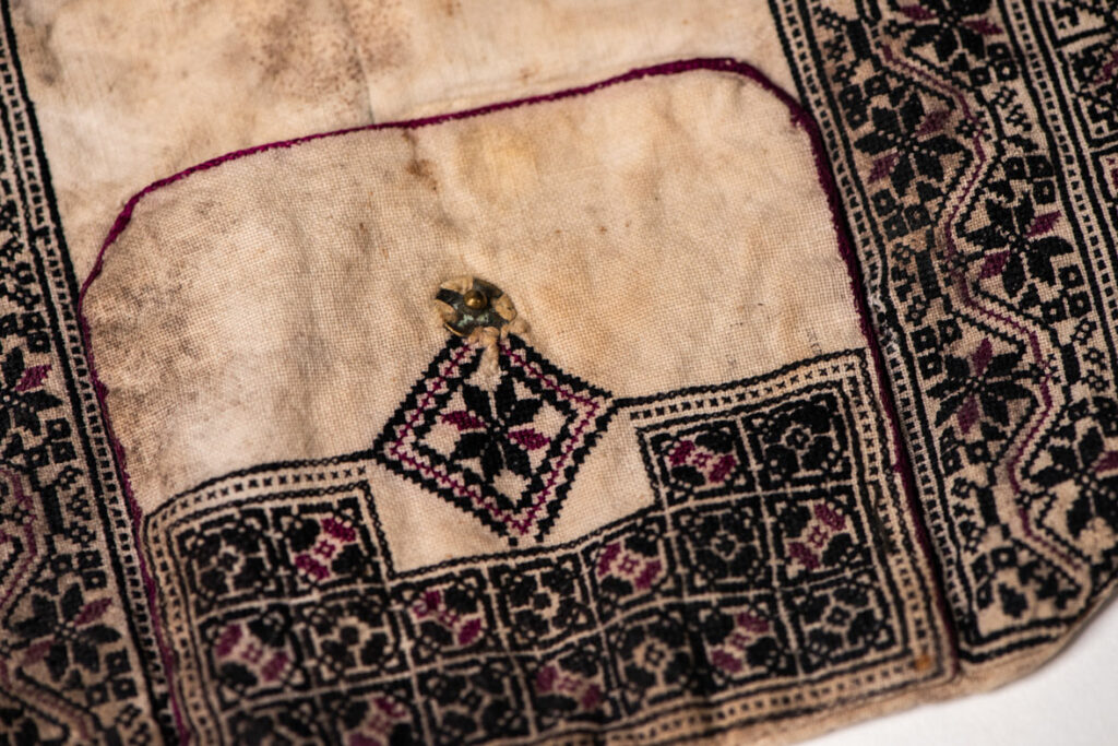 Ceremonial betel nut bag from the ami tribe, fully embroidered with distinctive motifs and inverted trapezoid shape.