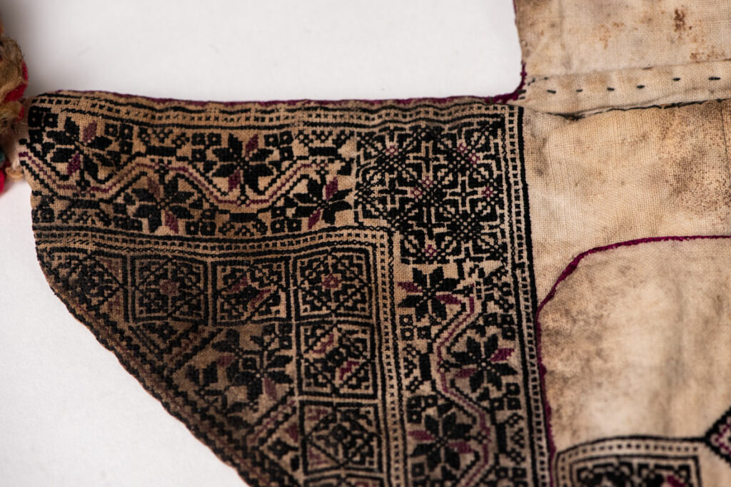 Ceremonial betel nut bag from the ami tribe, fully embroidered with distinctive motifs and inverted trapezoid shape.